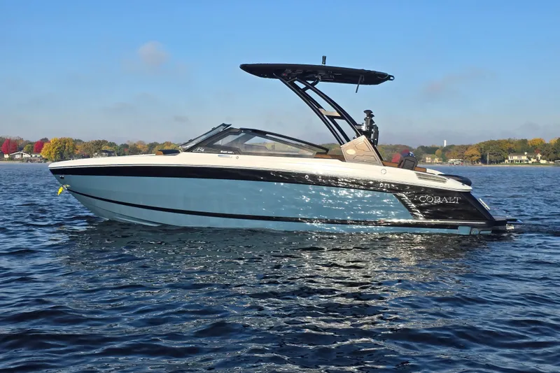 Slide: The Image of 2022 Cobalt R4 Surf boat on a lake with autumn trees in the background. - 7