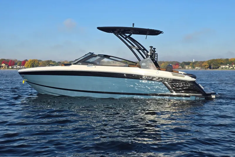 Slide: The Image of 2022 Cobalt R4 Surf boat on a serene lake with autumn foliage. - 8