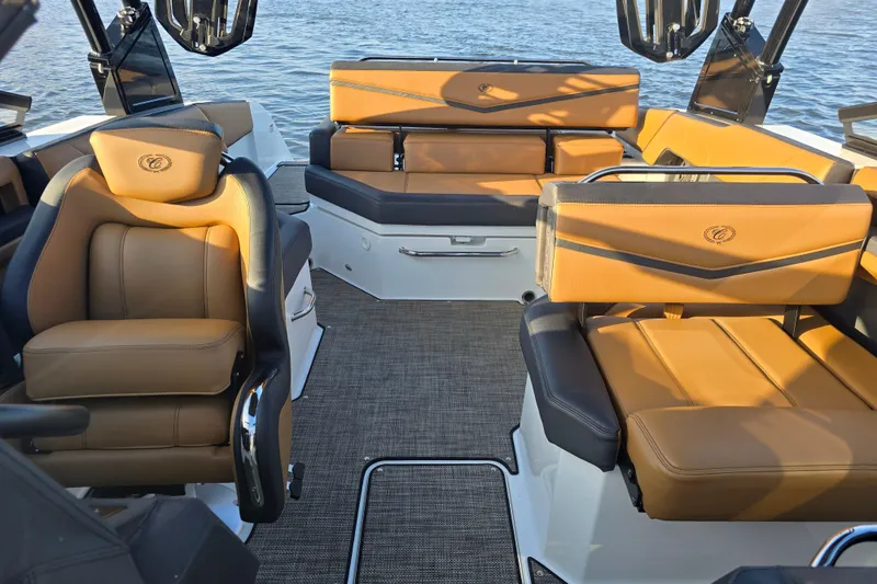 Slide: The Image of 2022 Cobalt R4 Surf boat interior with luxurious tan and black seating, on water. - 9