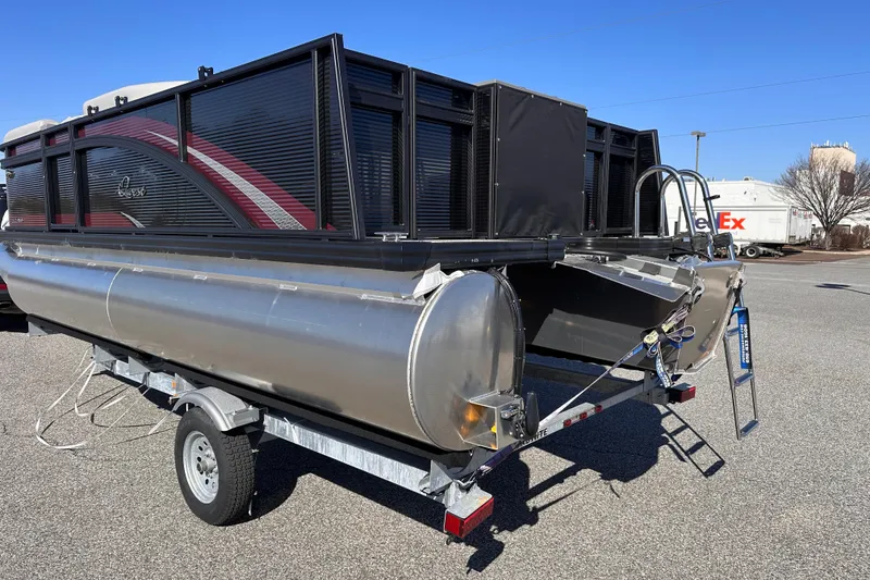 Slide: The Image of 2025 Qwest 18 XRE Cruise pontoon boat on trailer, parked outdoors. - 11