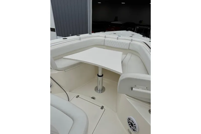 Slide: The Image of 2023 Cobia 301 Center Console boat interior with white seating and table. - 3