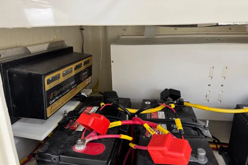 Slide: The Image of 2023 Cobia 301 Center Console battery compartment with charger and wiring. - 8