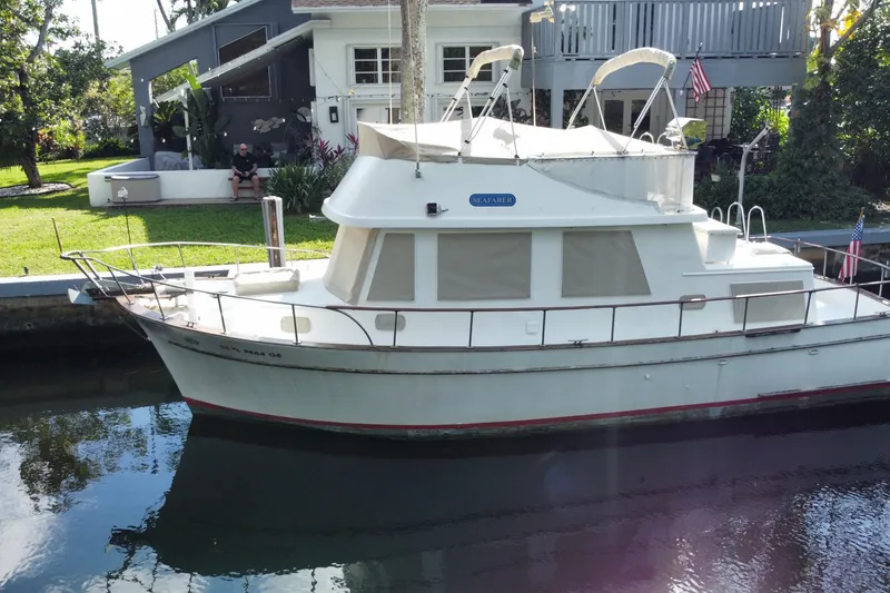 The Image of 1974 CHB 34 boat docked by a canal, with a house in the background. - 1