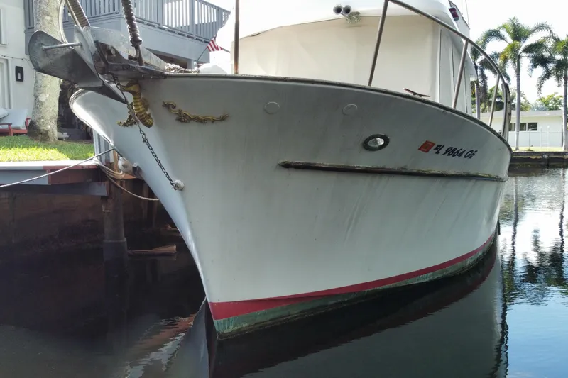 Slide: The Image of 1974 CHB 34 boat docked by a canal, featuring a classic design and white hull. - 10