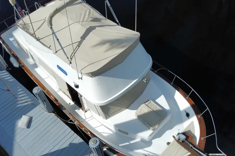 Slide: The Image of Aerial view of a 1974 CHB 34 boat docked, featuring a covered deck and classic design. - 12