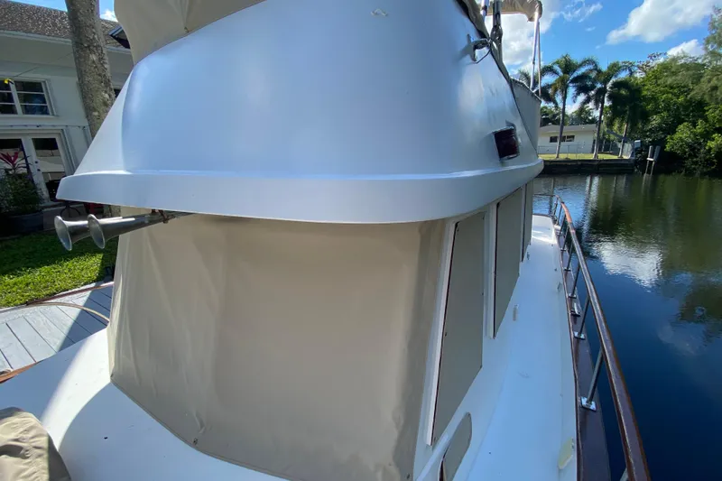 Slide: The Image of 1974 CHB 34 boat docked by a canal, surrounded by lush greenery. - 21