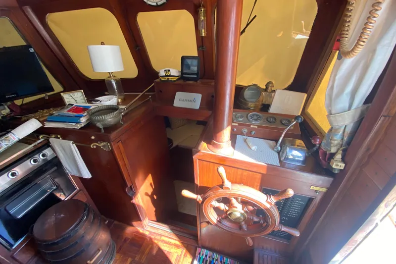 Slide: The Image of 1974 CHB 34 boat interior with wooden helm, vintage controls, and nautical decor. - 25