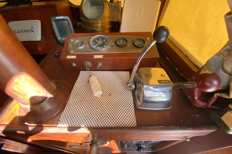 Slide: The Image of 1974 CHB 34 boat dashboard with throttle, gauges, and navigation equipment. - 27