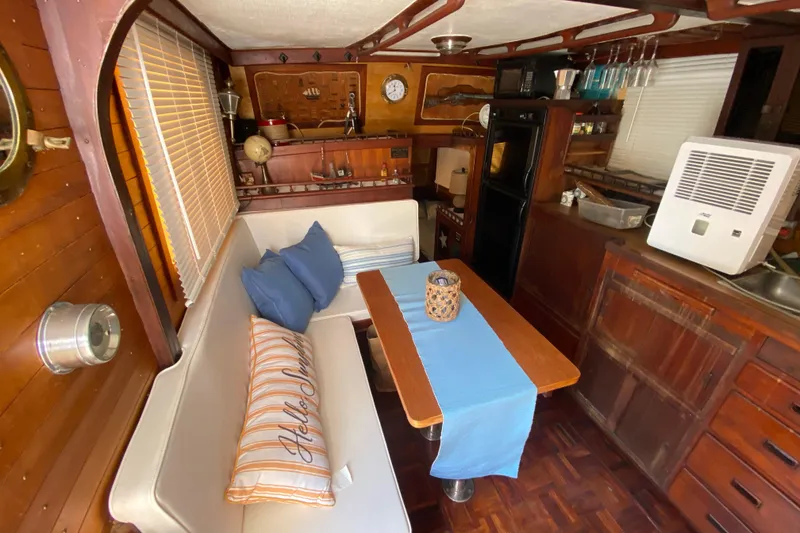 Slide: The Image of 1974 CHB 34 boat interior with cozy dining area, wooden decor, and nautical accents. - 28