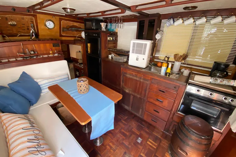 Slide: The Image of 1974 CHB 34 boat interior with cozy kitchen, dining area, and nautical decor. - 29