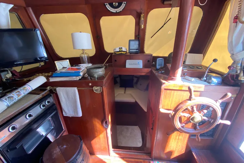 Slide: The Image of 1974 CHB 34 boat interior with wooden helm, navigation equipment, and cozy cabin space. - 30
