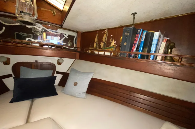 Slide: The Image of Cozy 1974 CHB 34 boat interior with books, pillows, and nautical decor. - 34