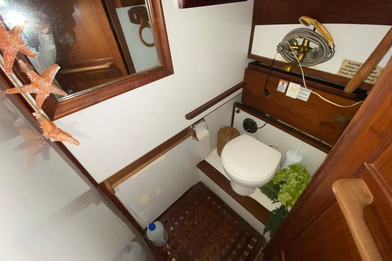 Slide: The Image of 1974 CHB 34 boat bathroom with wooden accents, starfish decor, and nautical elements. - 38