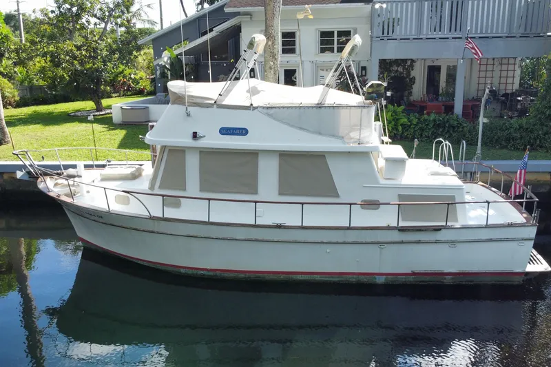 Slide: The Image of 1974 CHB 34 boat docked by a house with lush greenery. - 4