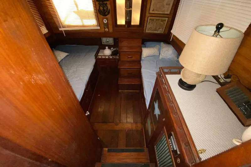 Slide: The Image of Cozy 1974 CHB 34 boat cabin with twin beds, wooden interior, and a table lamp. - 43