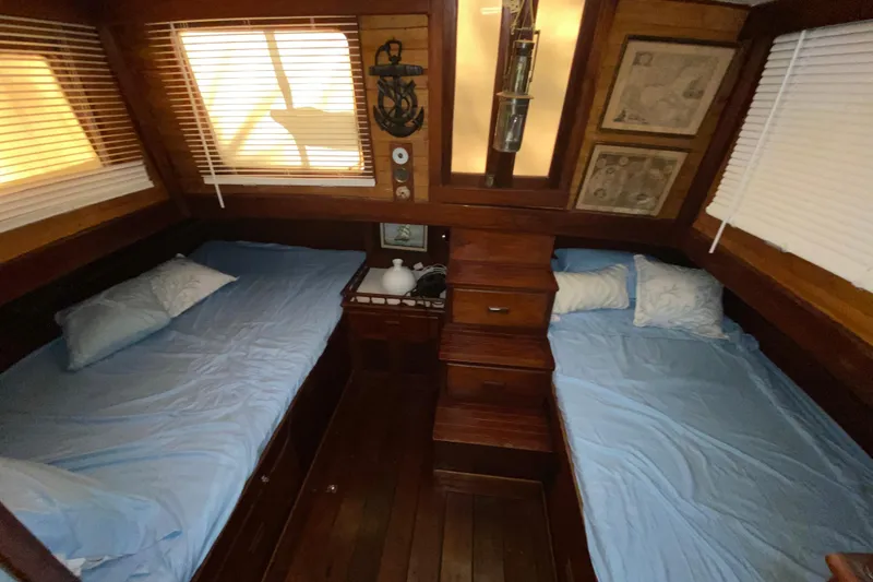 Slide: The Image of 1974 CHB 34 boat cabin with twin beds, wooden interior, and nautical decor. - 44