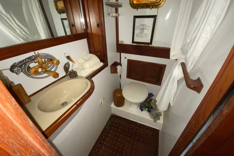 Slide: The Image of 1974 CHB 34 boat bathroom with sink, toilet, wooden accents, and nautical decor. - 47
