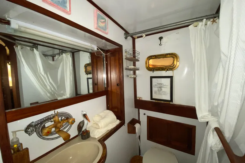 Slide: The Image of 1974 CHB 34 boat bathroom with wooden accents, porthole, and nautical decor. - 48