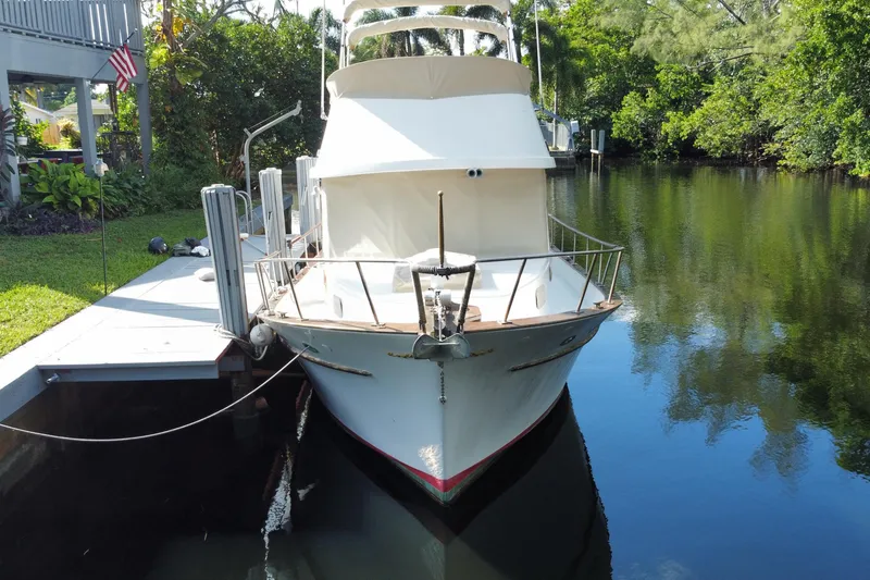 Slide: The Image of 1974 CHB 34 boat docked on a serene, tree-lined waterway. - 5