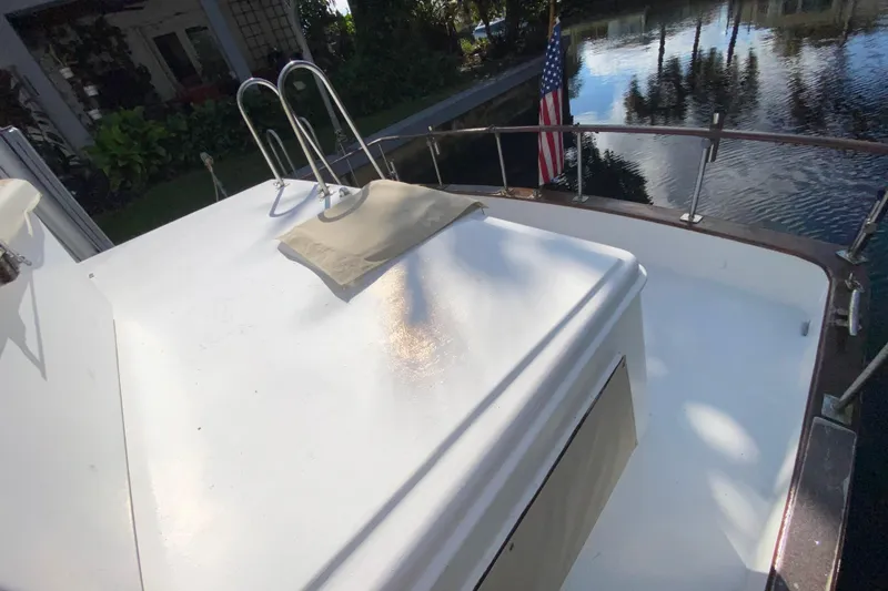 Slide: The Image of 1974 CHB 34 boat deck with American flag, docked by a serene waterway. - 52