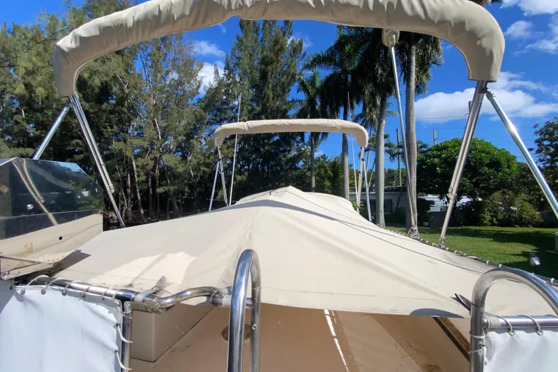 Slide: The Image of 1974 CHB 34 boat with canopy, surrounded by lush trees and clear blue sky. - 55