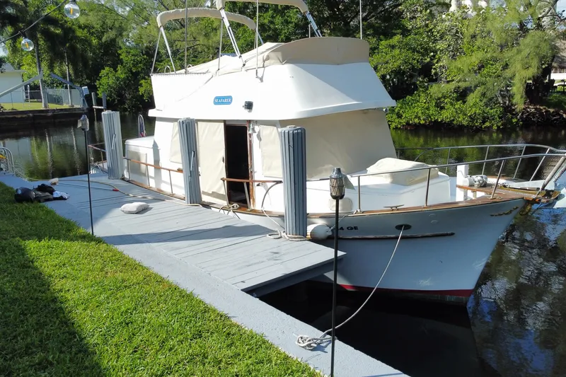 Slide: The Image of 1974 CHB 34 boat docked by a lush, green canal. - 6