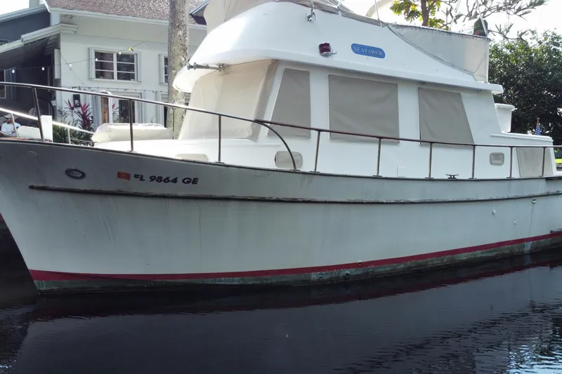 Slide: The Image of 1974 CHB 34 boat docked near a house, featuring a white exterior and covered windows. - 9