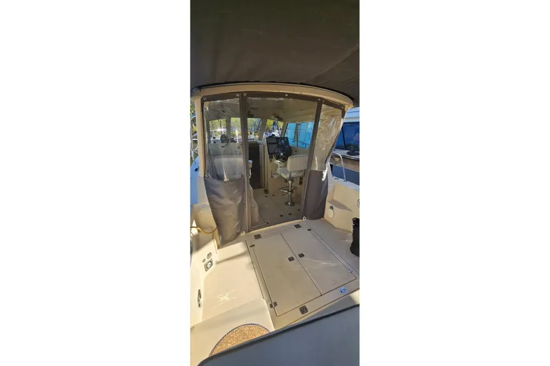 Slide: The Image of 2004 Albin 30 Family Cruiser interior with seating and helm, featuring clear enclosure. - 11