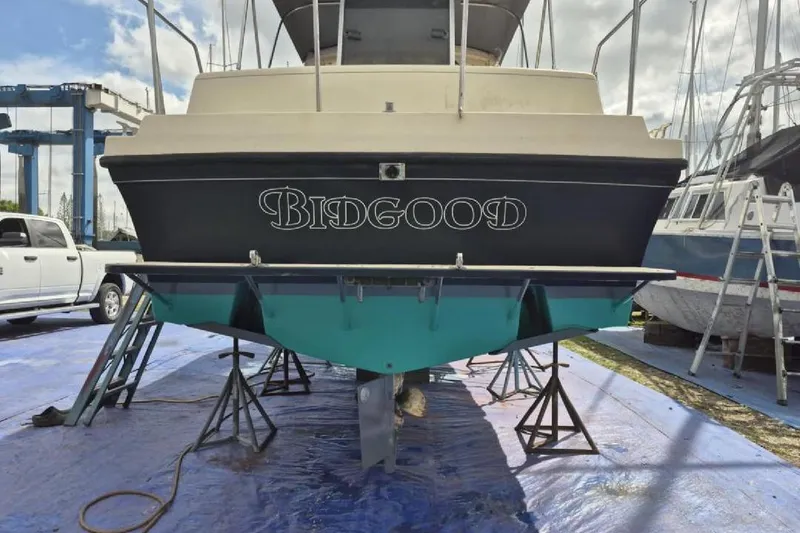 Slide: The Image of 2004 Albin 30 Family Cruiser on stands, with "Bidgood" name, in a boatyard setting. - 15
