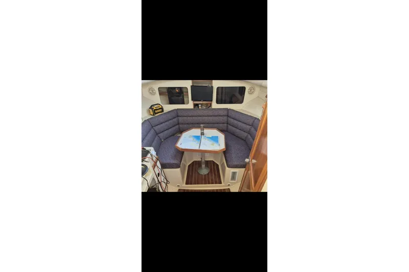 Slide: The Image of Interior of 2004 Albin 30 Family Cruiser with cozy seating and table. - 9
