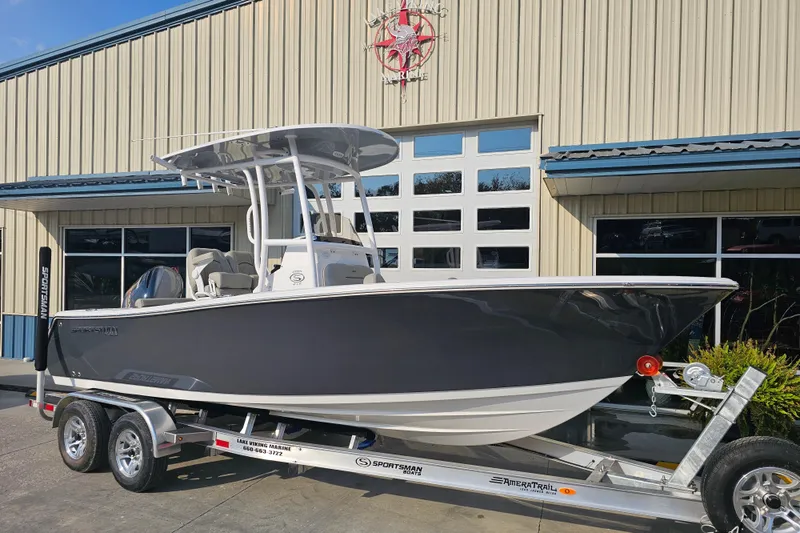 The Image of 2023 Sportsman Open 212 Center Console boat on trailer outside a building. - 1