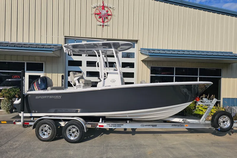 Slide: The Image of 2023 Sportsman Open 212 Center Console boat on trailer outside a marine shop. - 3