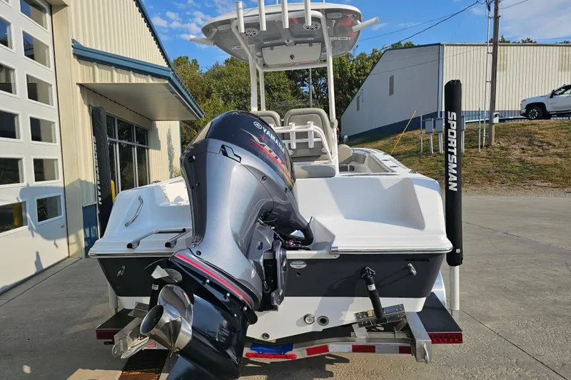 Slide: The Image of 2023 Sportsman Open 212 Center Console boat with Yamaha outboard motor, parked outside a building. - 6
