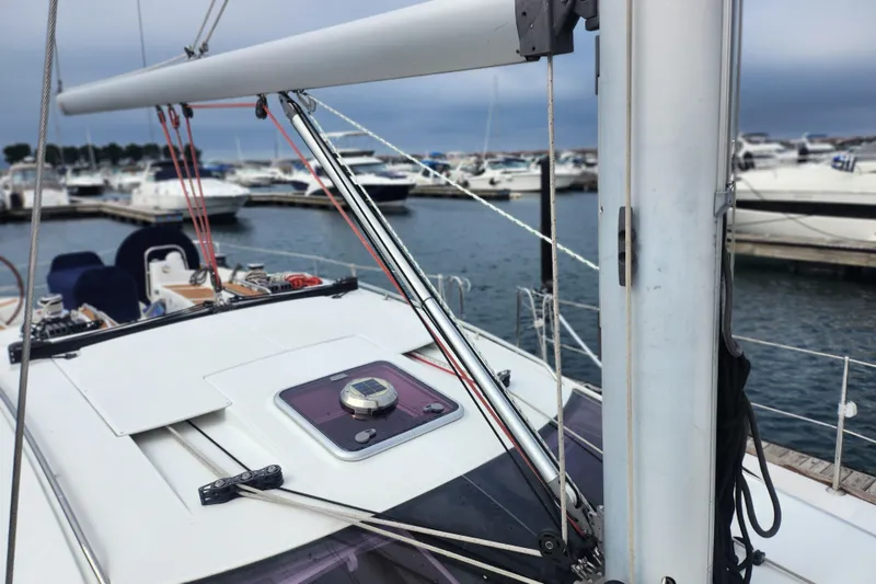 Slide: The Image of 2010 Jeanneau Sun Odyssey 45 DS sailboat docked in a marina, showcasing deck and rigging. - 11