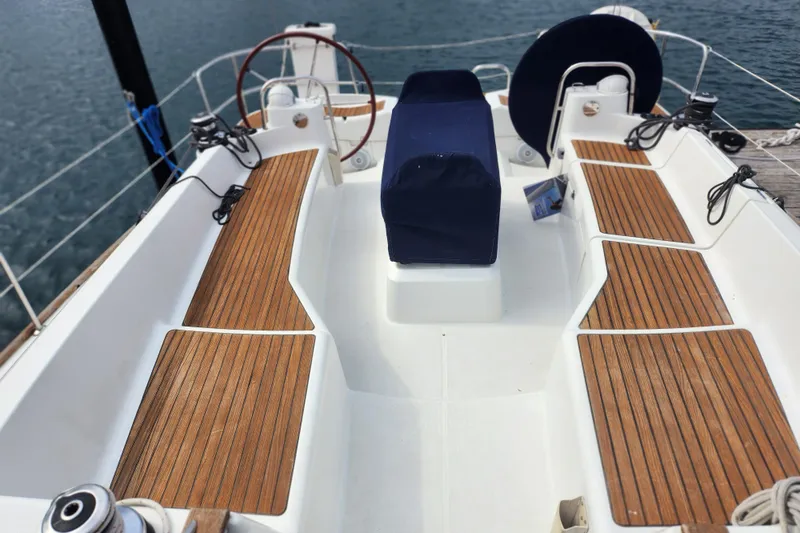 Slide: The Image of Cockpit of 2010 Jeanneau Sun Odyssey 45 DS with teak seating and dual steering wheels. - 12