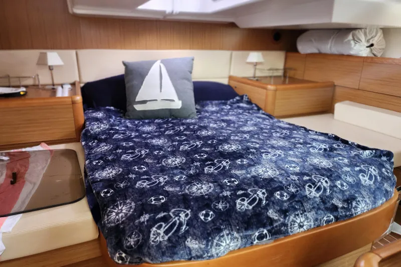 Slide: The Image of Cozy cabin interior of 2010 Jeanneau Sun Odyssey 45 DS with nautical-themed bedding. - 31