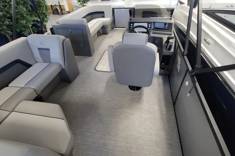 Slide: The Image of 2025 Qwest 22 Lanai E-Class TriToon interior with modern seating and steering console. - 3