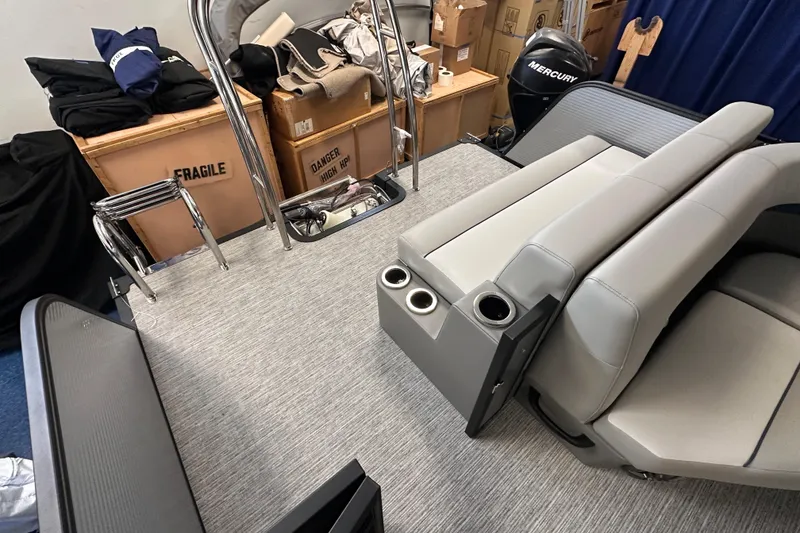 Slide: The Image of 2025 Qwest 22 Lanai E-Class TriToon interior with gray seating and storage boxes. - 9