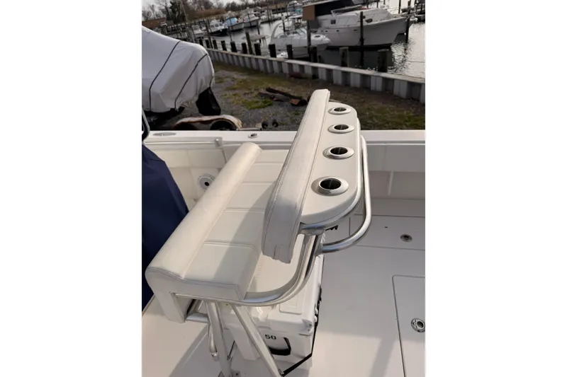 Slide: The Image of Contender boat seat with rod holders, docked near other boats in a marina. - 10