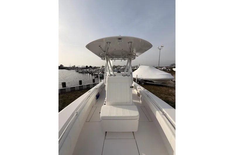 Slide: The Image of Contender boat with center console, docked near a marina under a clear sky. - 13