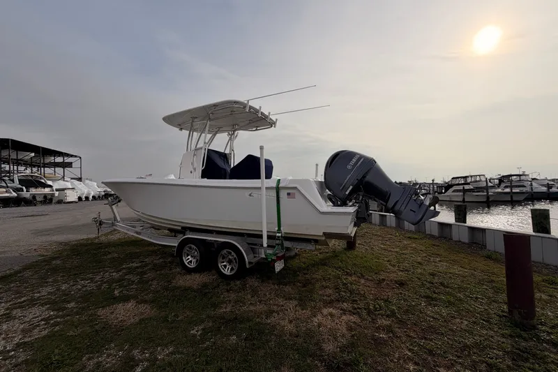 Slide: The Image of Contender boat on trailer near marina, with Yamaha outboard motor, under cloudy sky. - 2