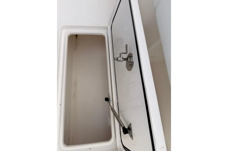 Slide: The Image of Open storage compartment on a Contender boat, featuring a secure latch mechanism. - 20