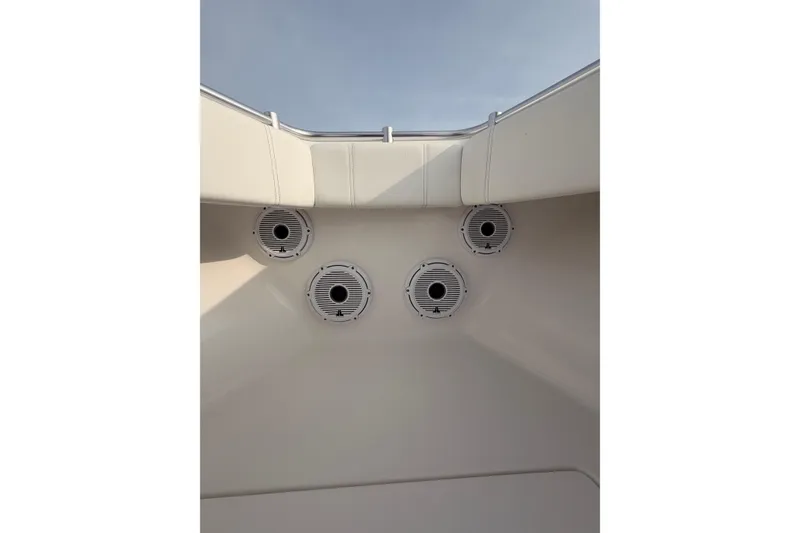 Slide: The Image of Contender boat interior with four circular speakers, white upholstery, and clear sky view. - 25