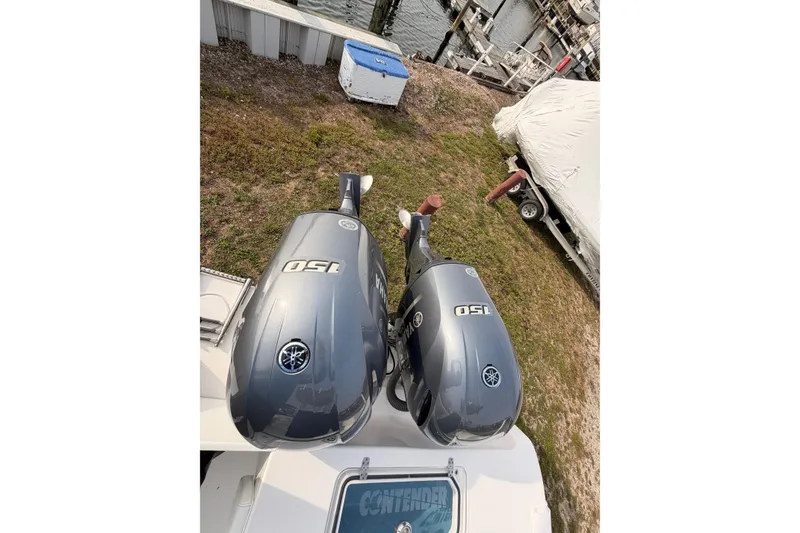 Slide: The Image of Twin Yamaha 150 outboard motors on a Contender boat near a dock. - 26