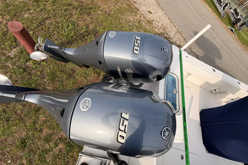 Slide: The Image of Twin Yamaha 150 outboard motors on a Contender boat, parked on grass. - 27