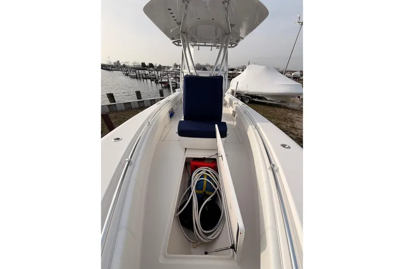 Slide: The Image of Contender boat interior with storage compartment, blue seating, and marina background. - 5