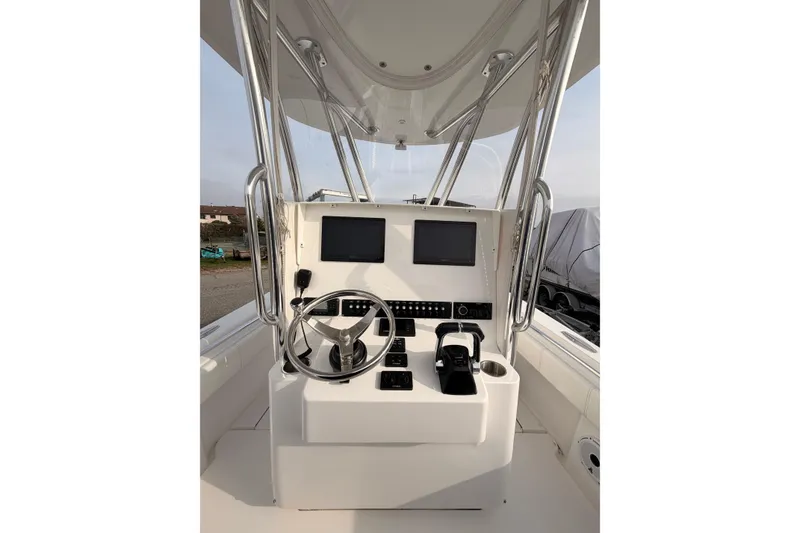 Slide: The Image of Contender boat helm with dual screens, steering wheel, and controls. - 6