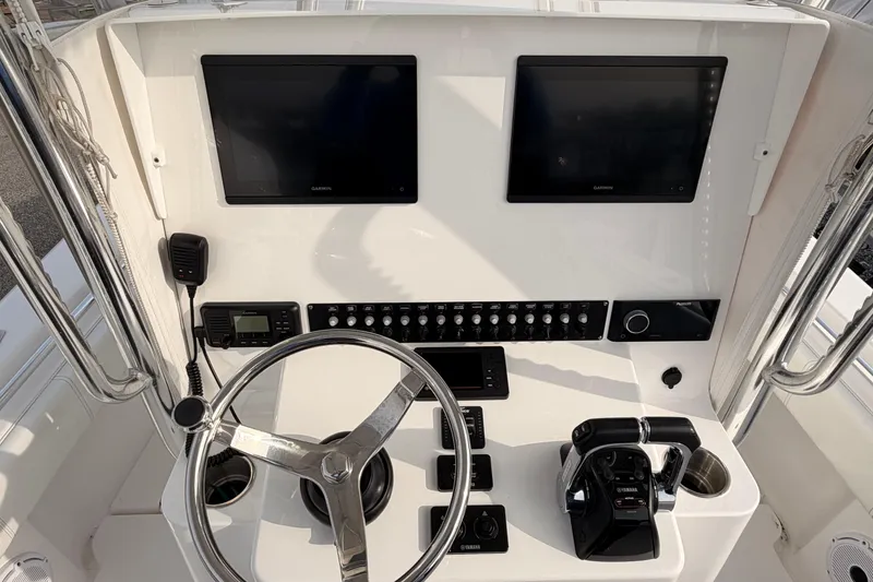 Slide: The Image of Boat helm with dual Garmin screens, steering wheel, and Yamaha controls on Contender model. - 7