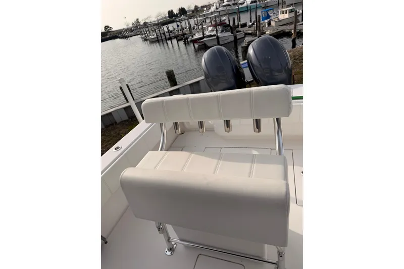 Slide: The Image of Contender boat with dual engines and white seating at a marina dock. - 8