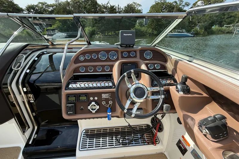 Slide: The Image of 2013 Cobalt 323 boat dashboard with steering wheel, controls, and navigation system. - 10